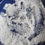 Uomo che spruzza bicarbonato in un orto per combattere parassiti e mantenere piante sane.