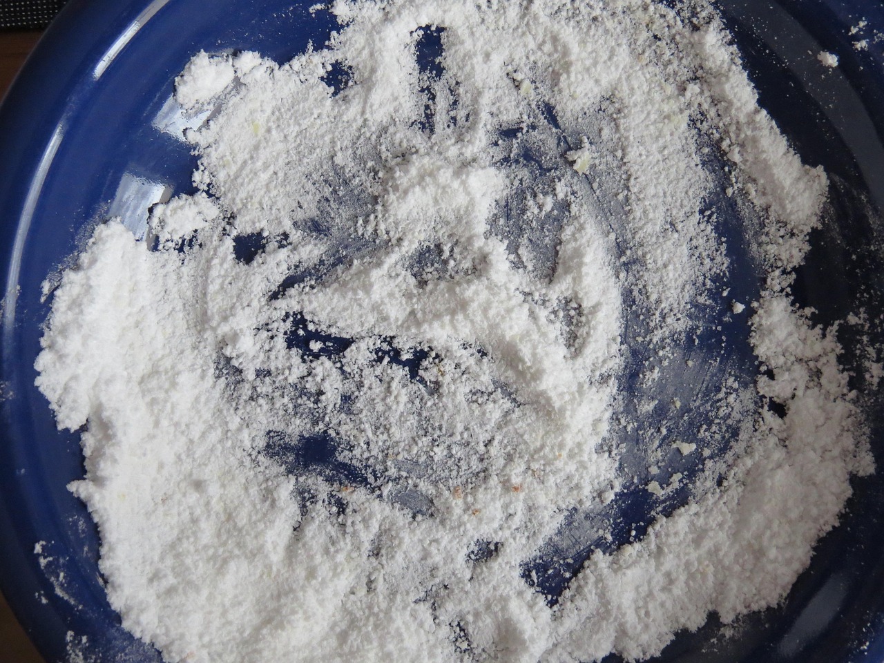 Uomo che spruzza bicarbonato in un orto per combattere parassiti e mantenere piante sane.