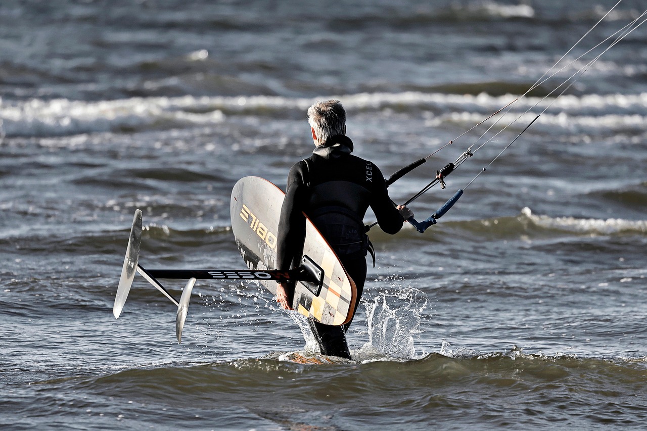 Kitesurfista in azione su un'onda, evidenziando la bellezza e i rischi dello sport acquatico.